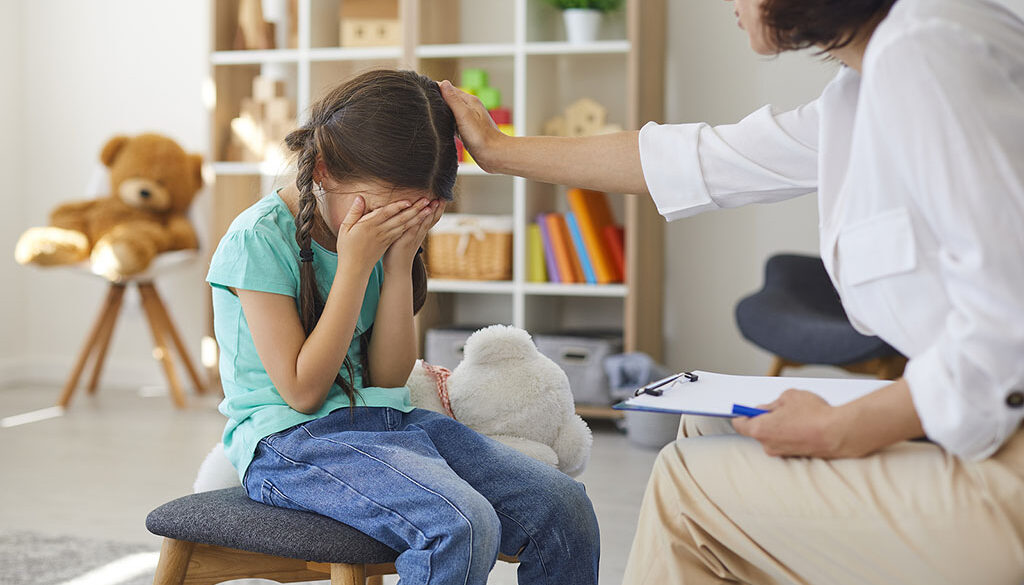 A Therapist Counseling A Young Girl Sitting On A Stool With Her Hands Covering Her Face Grief Counseling For Children