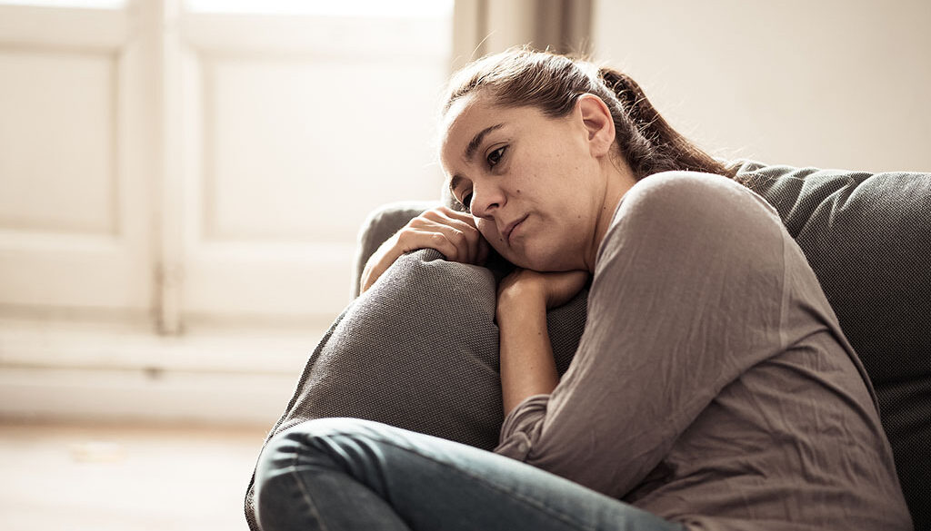 A Woman Lying On A Couch With A Depressed Look On Her Face Prolonged Grief Disorder